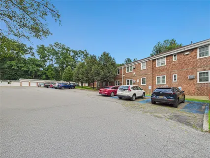 a bedroom with a bed a chair and a flat screen tv