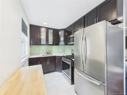 a kitchen with granite countertop a refrigerator and a sink