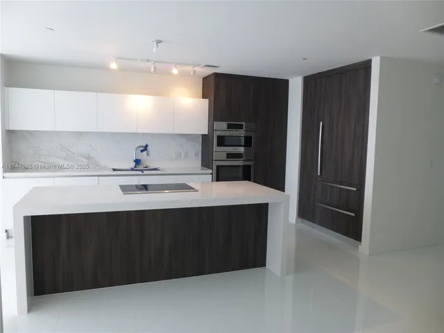 a kitchen with stainless steel appliances a sink and refrigerator