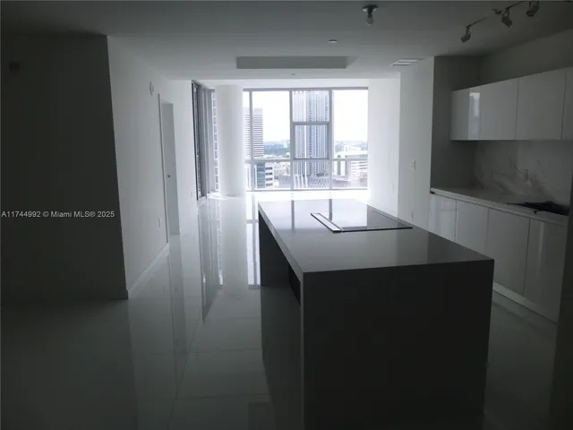 a kitchen with kitchen island a sink stainless steel appliances and a window