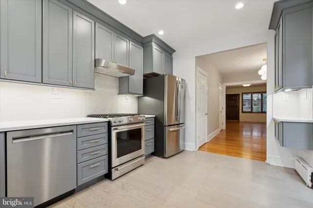 a kitchen with stainless steel appliances granite countertop a stove a refrigerator and a sink with granite countertops
