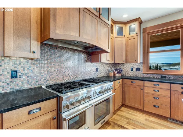 a kitchen with stainless steel appliances granite countertop a stove a sink and a microwave