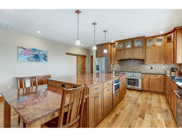 a kitchen with stainless steel appliances kitchen island granite countertop a stove a sink and a refrigerator