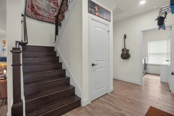 a view of a hallway with wooden floor and staircase
