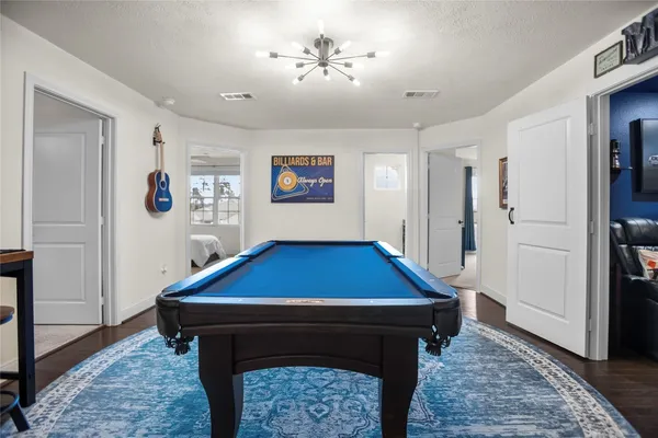 a room with pool table and paintings on wall