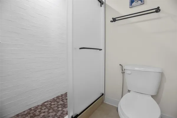 a white toilet sitting next to a shower