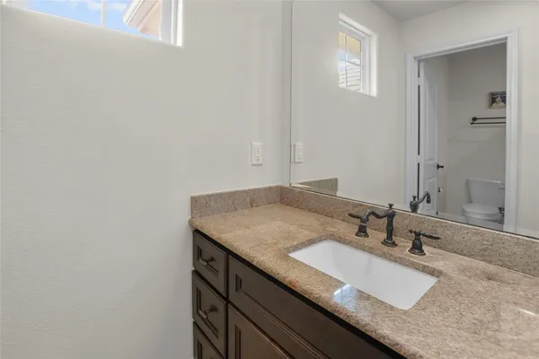 a bathroom with a granite countertop sink and a mirror