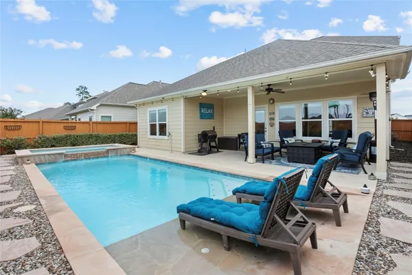 a swimming pool with outdoor seating and yard