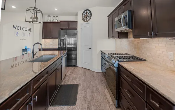 a kitchen with stainless steel appliances granite countertop a sink stove and cabinets