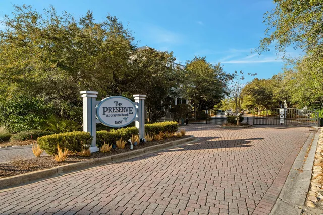 a sign board with a bench and trees