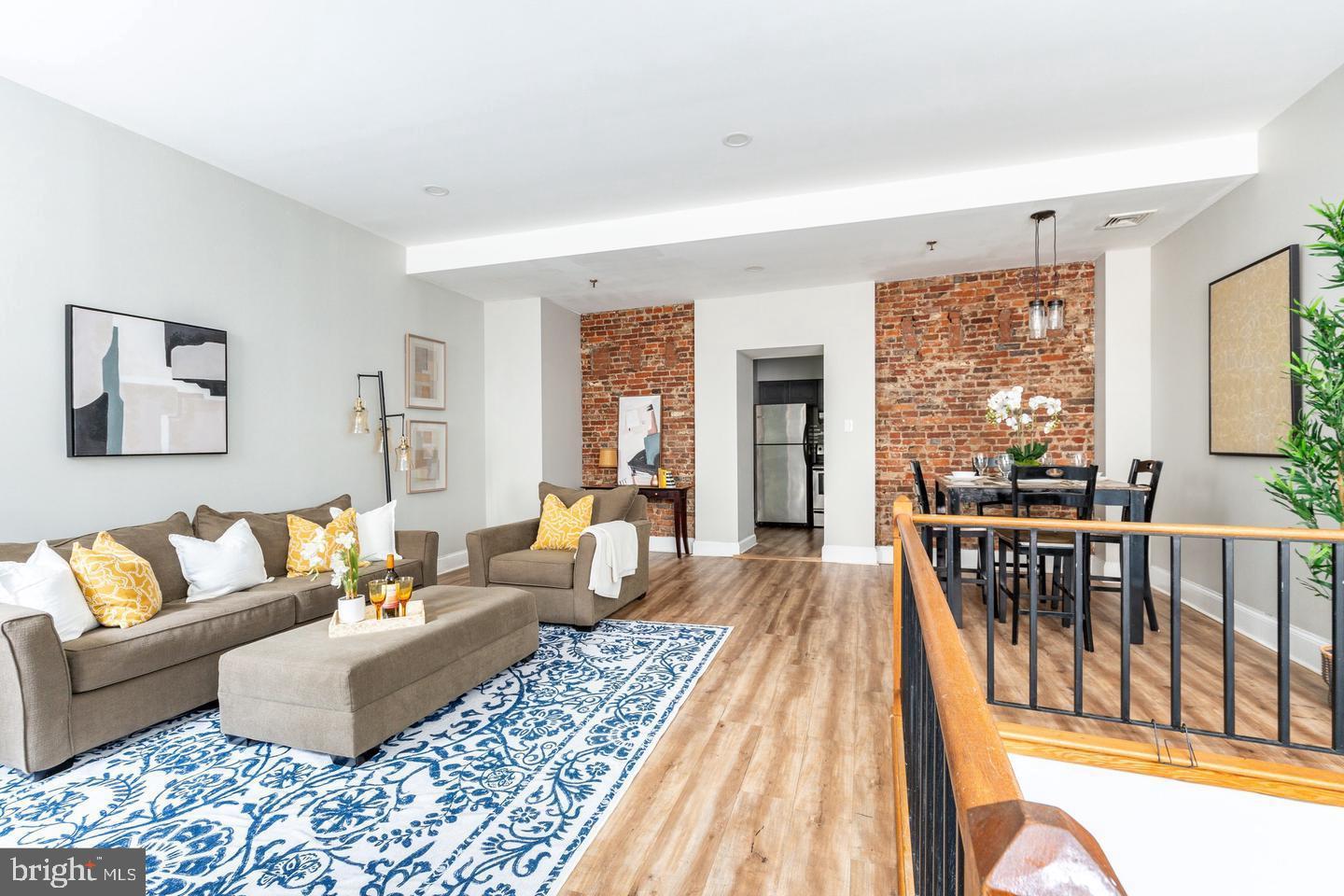 101 Arch Street, Unit 1J Philadelphia, PA 19106 - Photo 8 of 29 a living room with furniture wooden floor and a floor to ceiling window