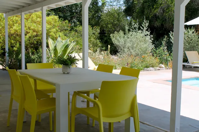 a view of an outdoor dining space with a table and chairs