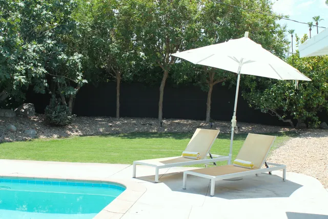a view of backyard with swimming pool and patio