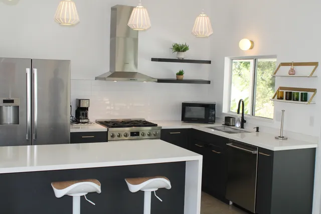 a kitchen with stainless steel appliances a stove a sink and a refrigerator