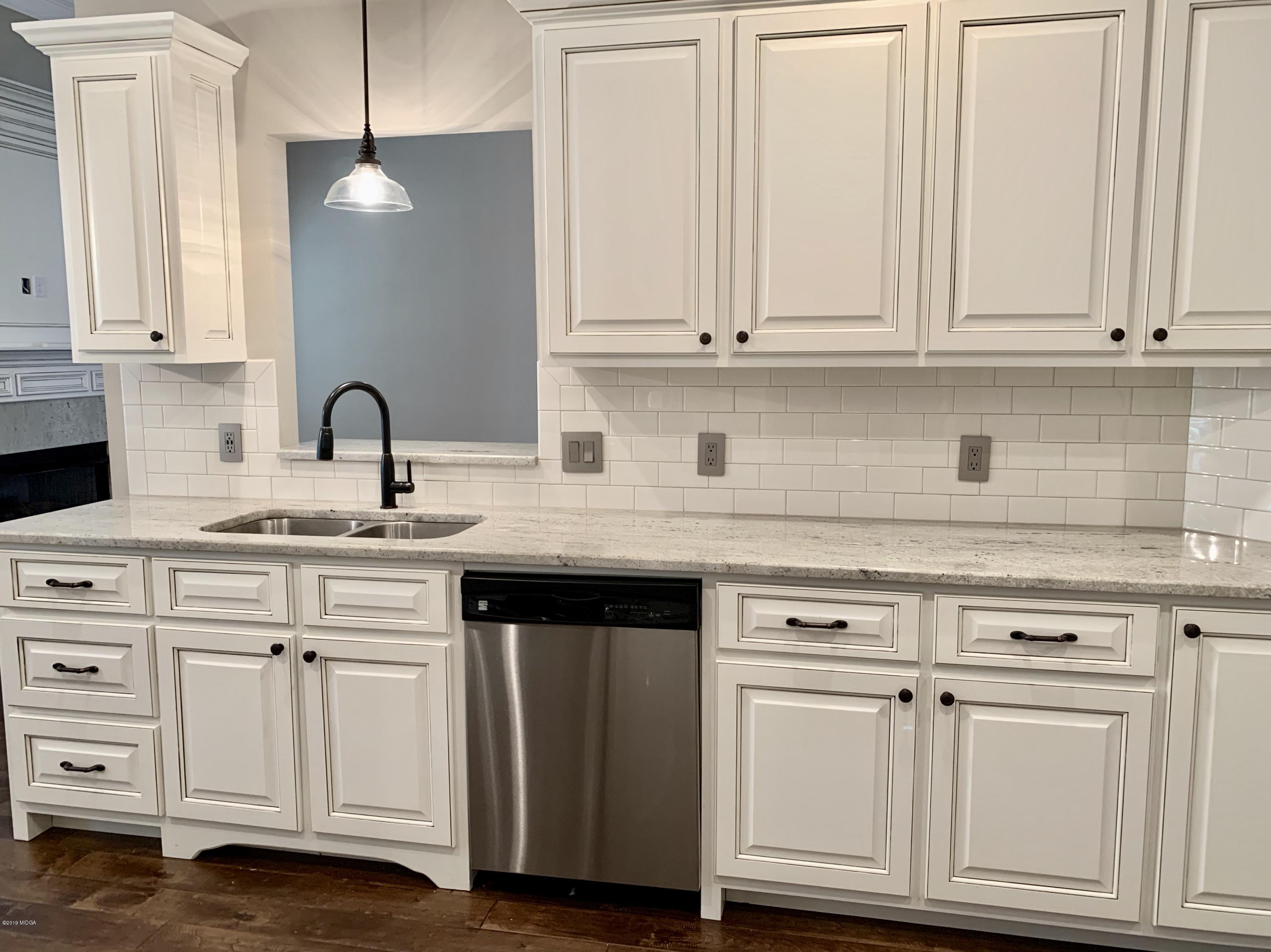 208 Bridgehampton Way Perry, GA 31069 - Photo 9 of 37 a kitchen with white cabinets and sink