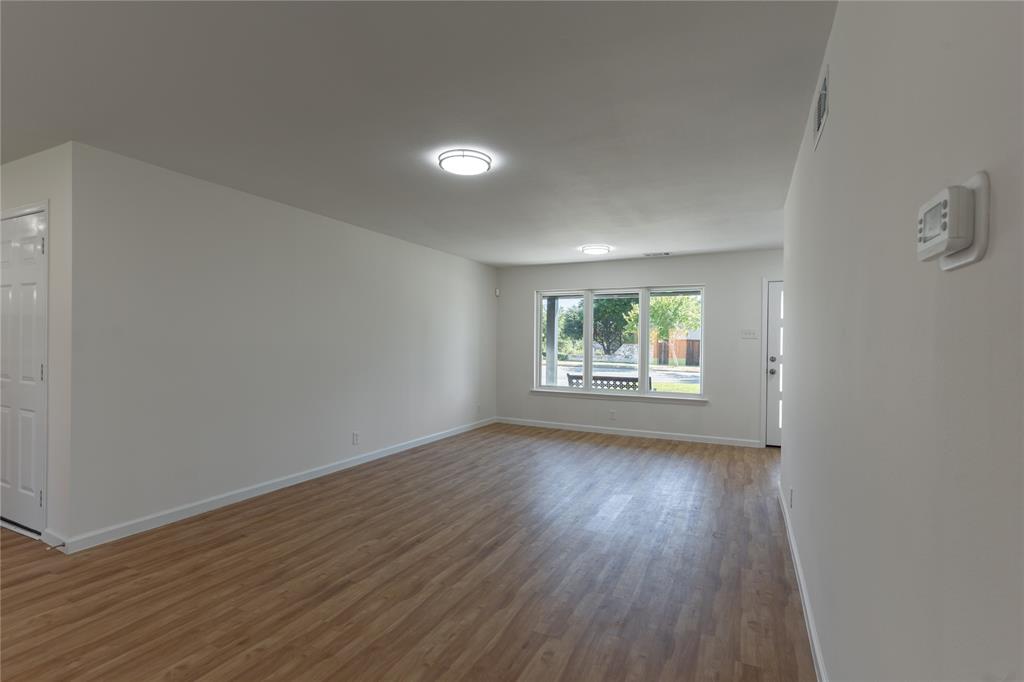9225 Plano Road Dallas, TX 75238 - Photo 6 of 24 an empty room with wooden floor and windows
