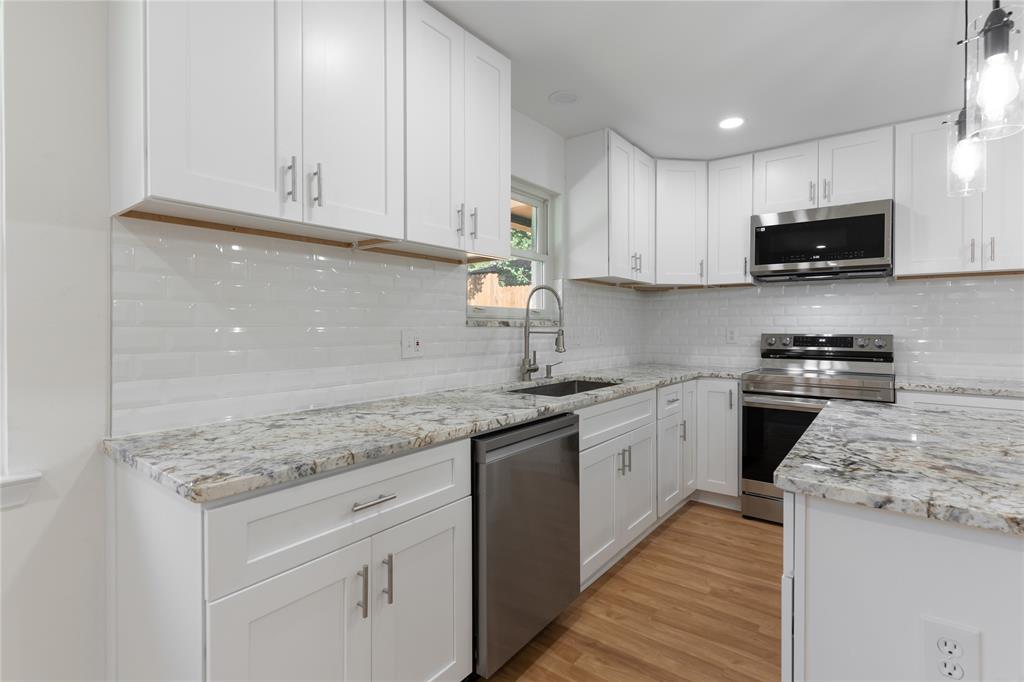 9225 Plano Road Dallas, TX 75238 - Photo 9 of 24 a kitchen with stainless steel appliances granite countertop a sink stove and cabinets