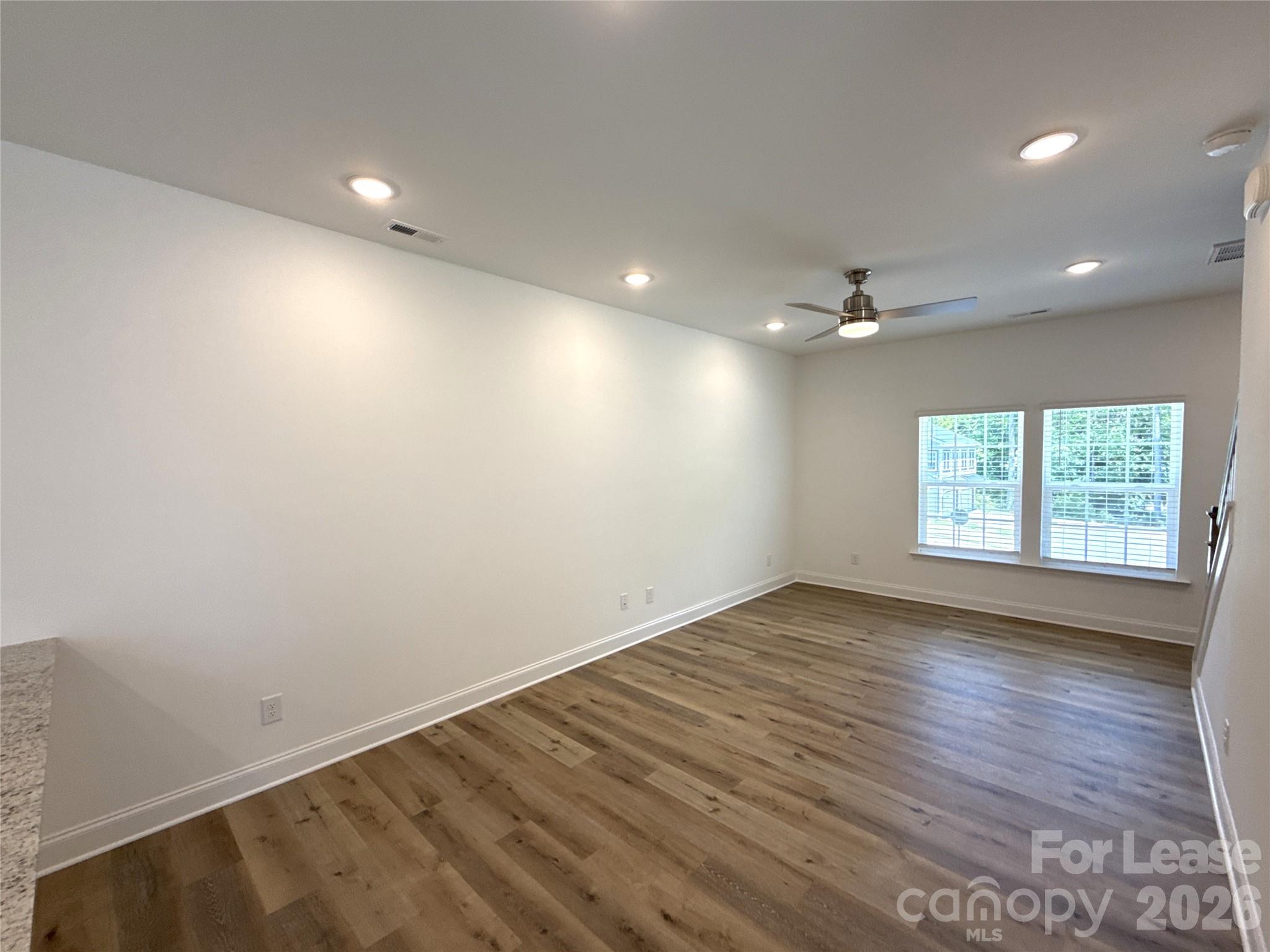 3220 Butler Hl Drive Matthews, NC 28105 - Photo 2 of 11 an empty room with wooden floor and windows