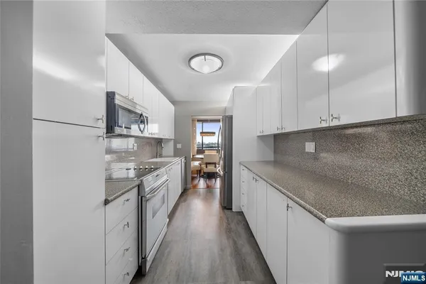 a kitchen with stainless steel appliances granite countertop a sink and cabinets