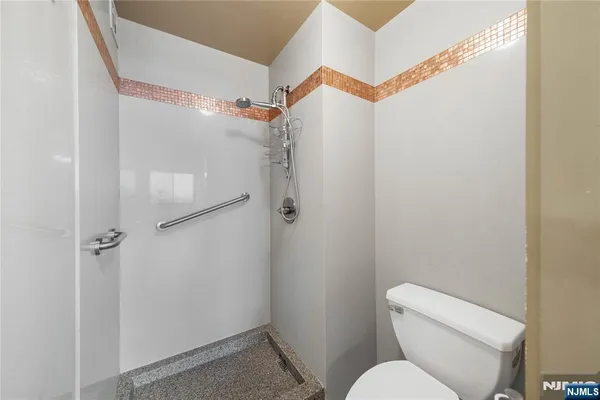 a white toilet sitting next to a shower