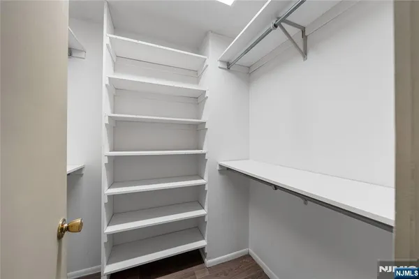 a view of walk in closet with empty racks