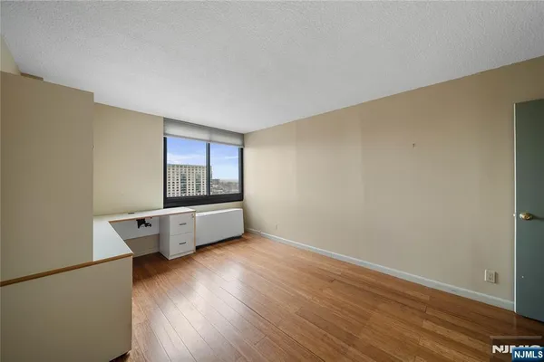 an empty room with wooden floor and window