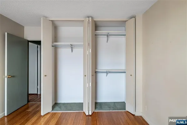 a view of walk in closet with wooden floor