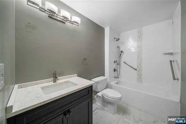 a bathroom with a granite countertop sink toilet a shower and a mirror