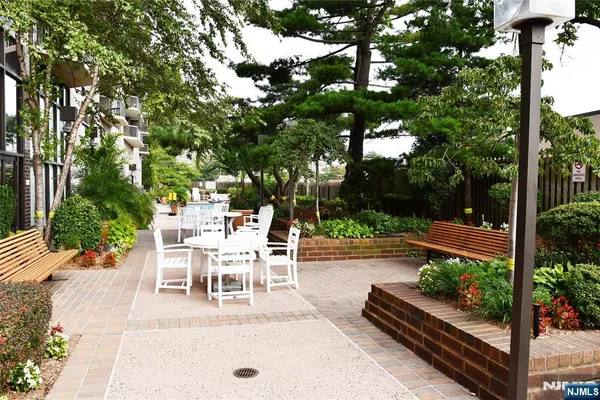 a view of a patio with table and chairs potted plants and large tree