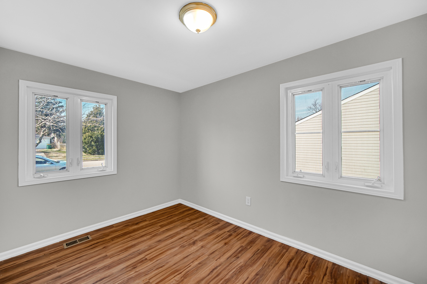 407 Dalhart Avenue Romeoville, IL 60446 - Photo 13 of 17 an empty room with wooden floor and windows