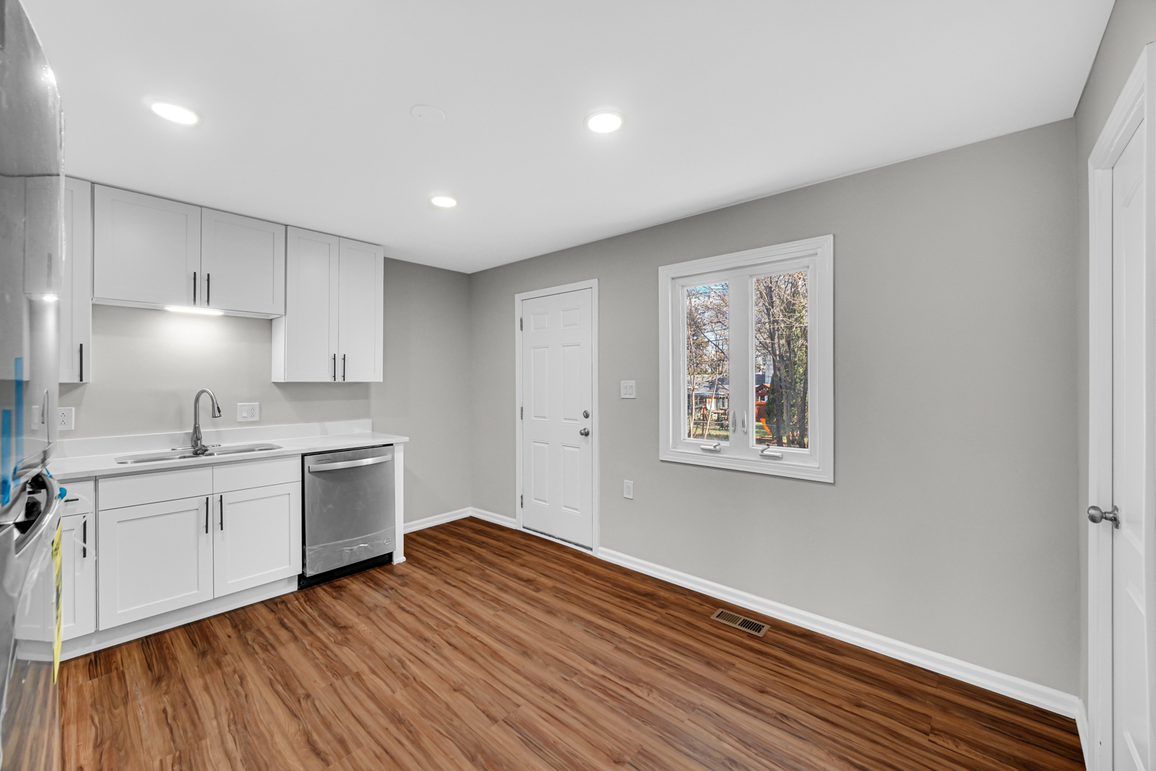 407 Dalhart Avenue Romeoville, IL 60446 - Photo 2 of 17 a kitchen with granite countertop a stove a sink and white cabinets with wooden floor