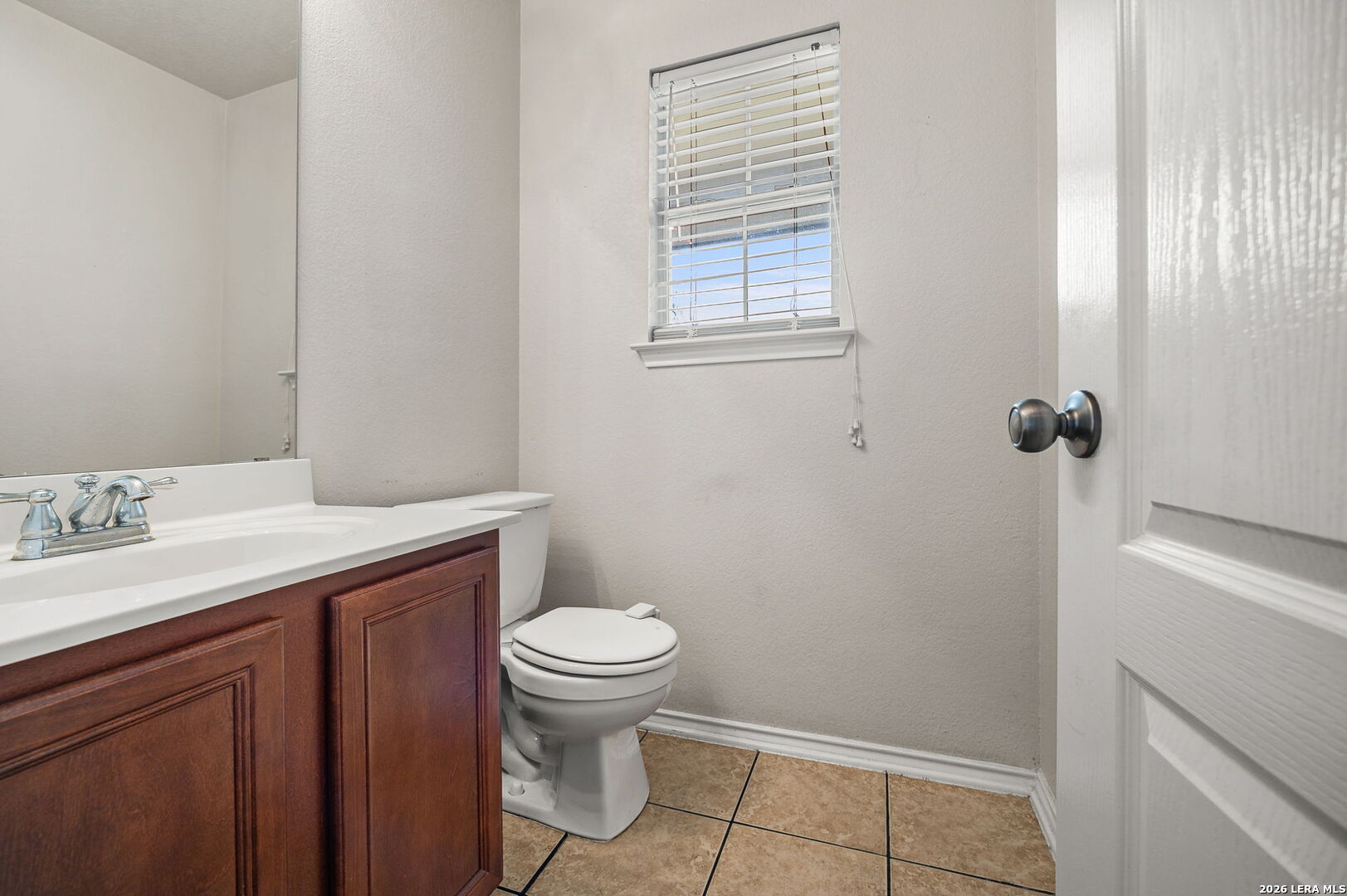 7207 Avery Road Live Oak, TX 78233 - Photo 10 of 32 a bathroom with a sink a toilet and a window