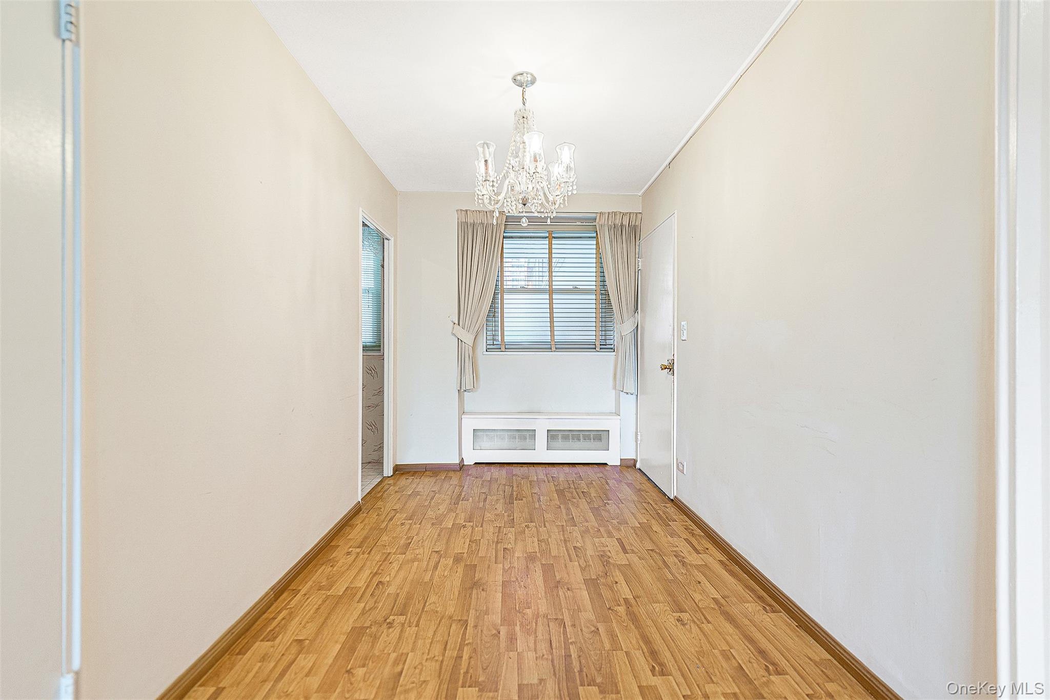 97-37 63rd Road, Unit 2/B Queens, NY 11374 - Photo 4 of 26 an empty room with wooden floor door and windows