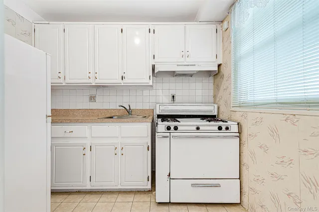 a kitchen with white cabinets and white appliances