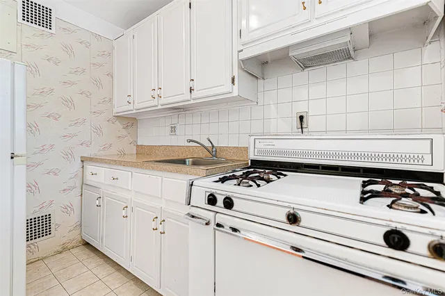 a white stove top oven sitting inside of a kitchen