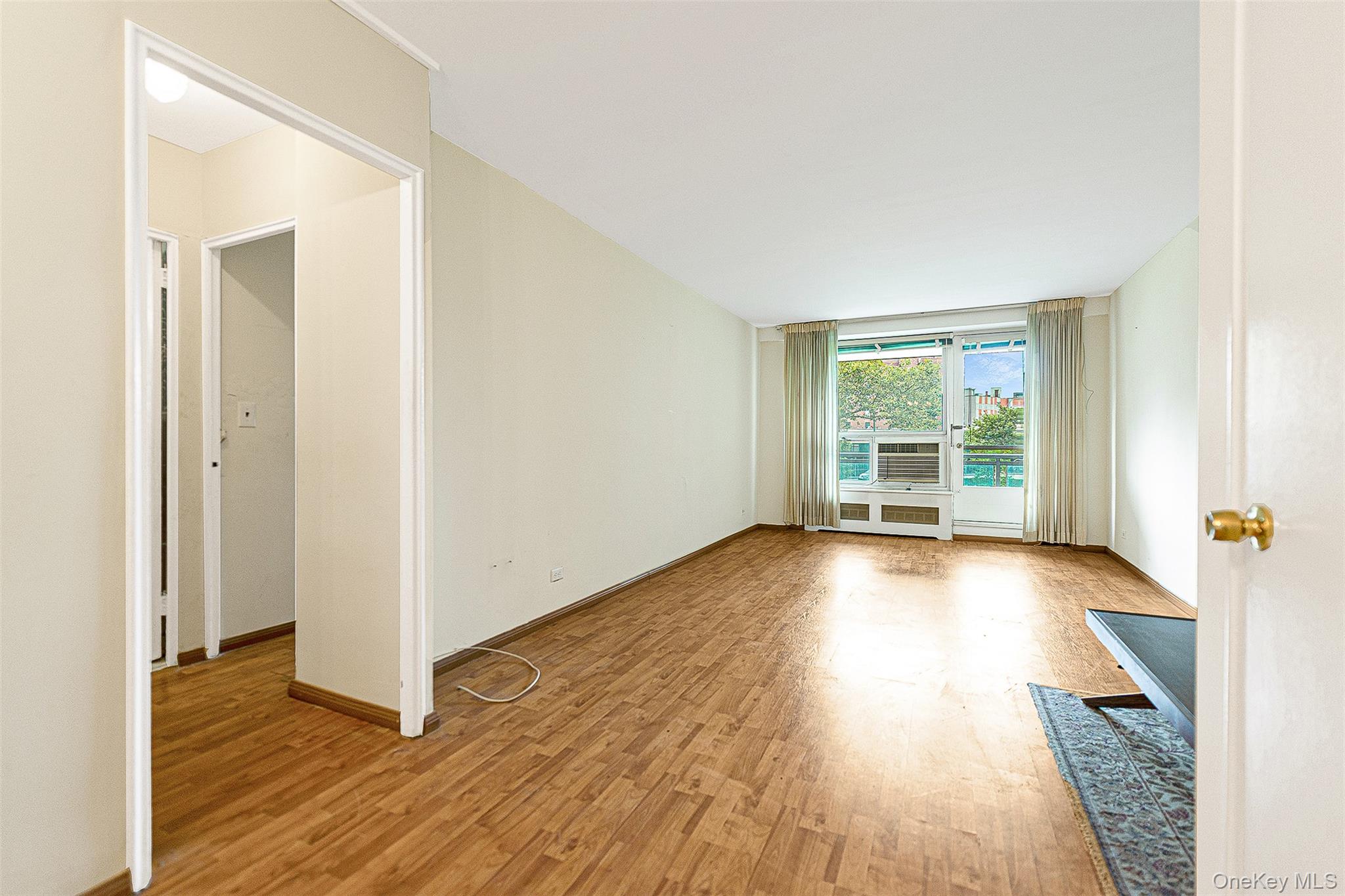 97-37 63rd Road, Unit 2/B Queens, NY 11374 - Photo 8 of 26 an empty room with wooden floor and windows