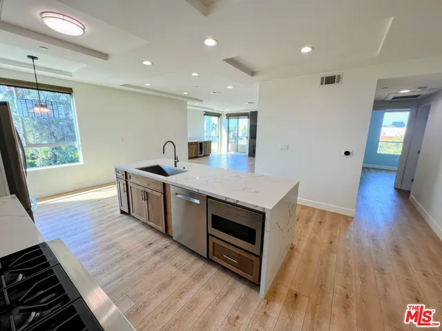 a kitchen with granite countertop a stove and a wooden floor