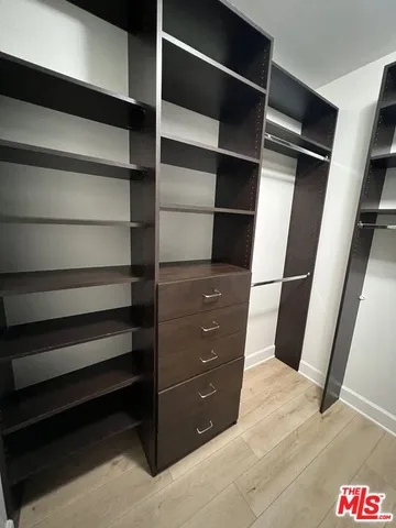a view of walk in closet with empty racks