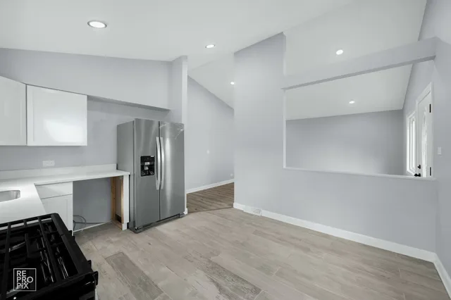 a kitchen with stainless steel appliances a refrigerator and a stove top oven