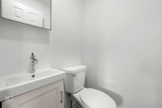 a white toilet sitting next to a white sink