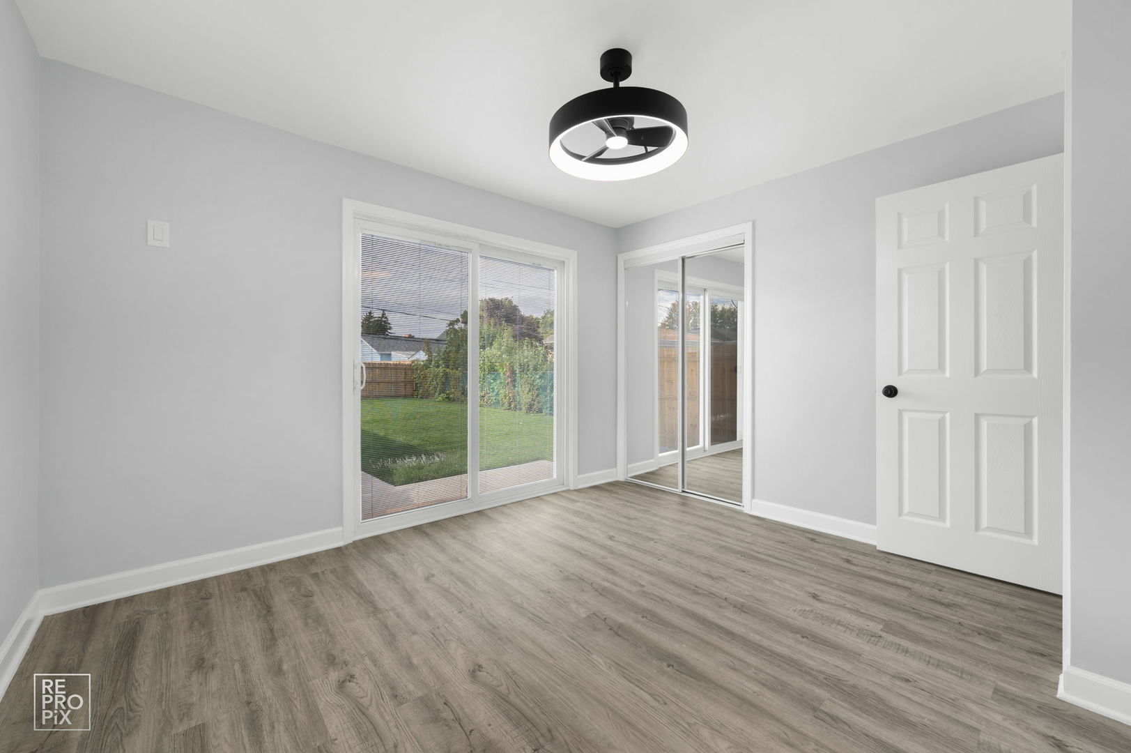 7616 South 78th Avenue Bridgeview, IL 60455 - Photo 6 of 10 a view of an empty room with a window and wooden floor