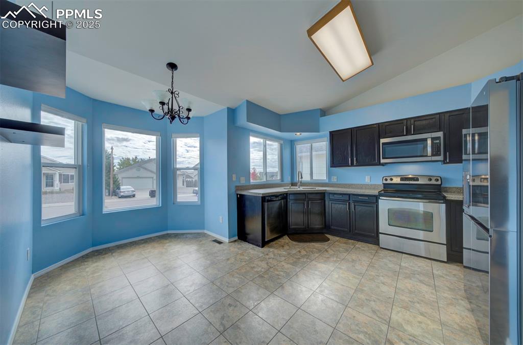 8072 Oliver Road Peyton, CO 80831 - Photo 5 of 30 a kitchen with stainless steel appliances granite countertop a stove sink and microwave