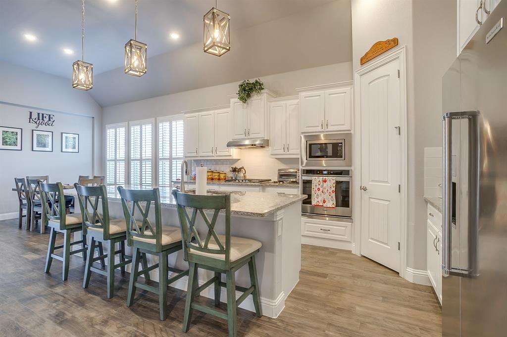 11829 Kynborrow Road Fort Worth, TX 76052 - Photo 14 of 39 a kitchen with stainless steel appliances kitchen island granite countertop a table chairs and a refrigerator