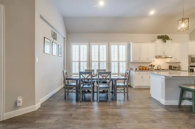 a dining room with kitchen island furniture a large window and kitchen view