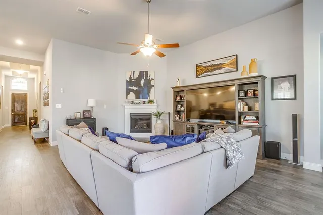 a living room with furniture a flat screen tv and a fireplace