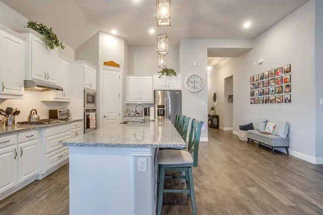 a large kitchen with granite countertop a lot of counter space and wooden floor