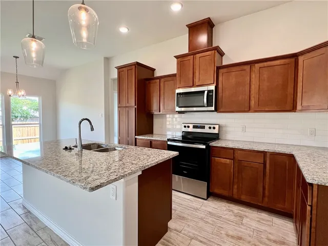 a kitchen with granite countertop a stove and a sink