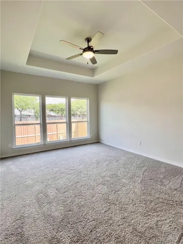 an empty room with windows and ceiling fan