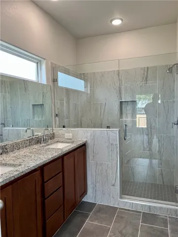 a bathroom with a granite countertop sink a shower and a mirror