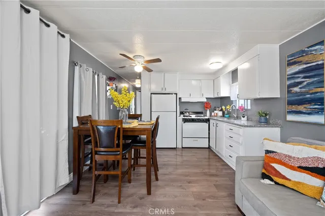 a kitchen with a dining table chairs and cabinets